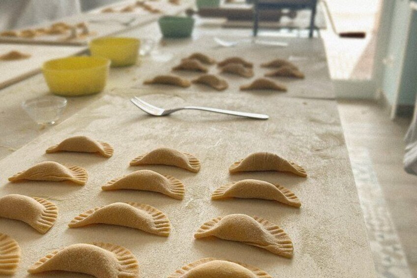 A table with neatly arranged pastry shells, a spoon, and bowls in the background. 4