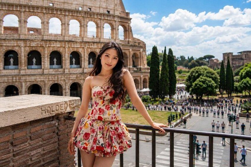 A person in a floral dress standing in front of the Colosseum with a clear sky and trees in the background. 5
