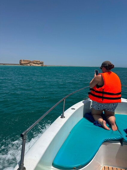 A person on a boat wearing a life jacket, looking at a smartphone. 3