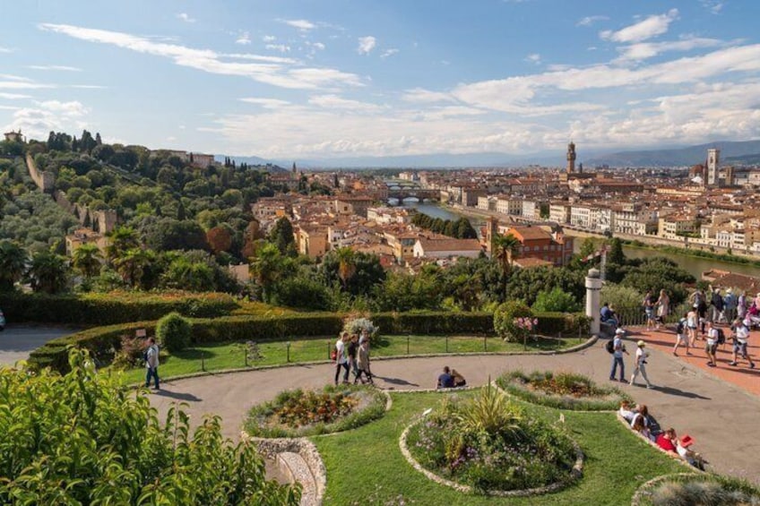 A park with manicured gardens, a river, and a cityscape in the background. 5