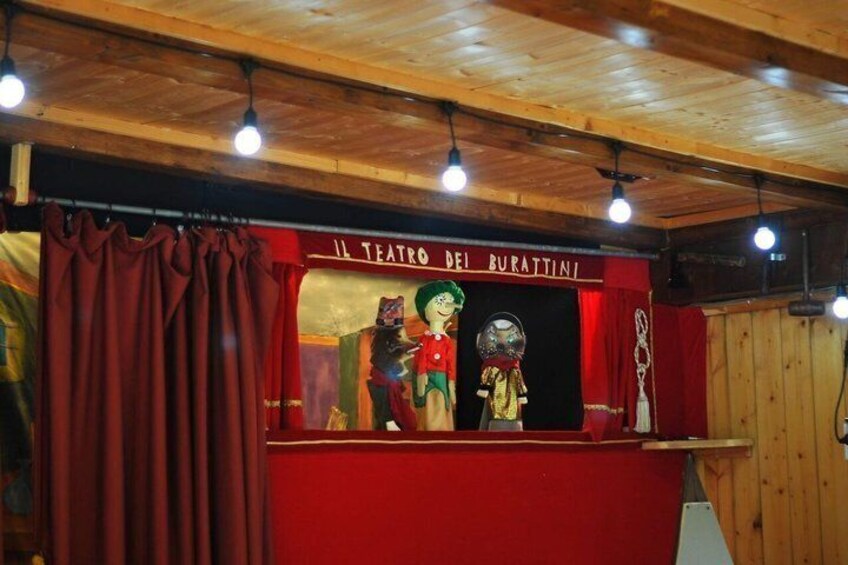A theater with a red curtain and wooden ceiling. 4