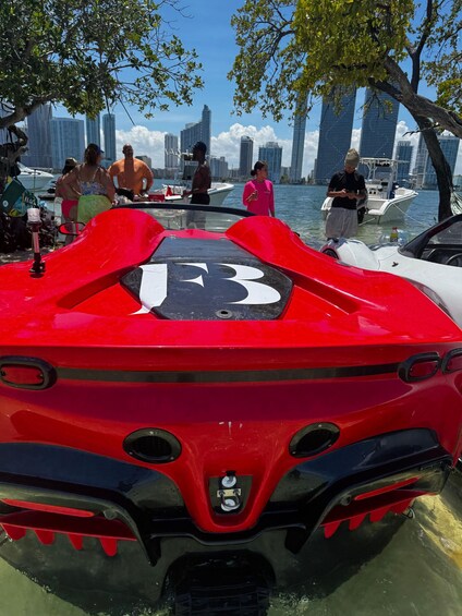 A red jet ski with a number '13' on its back, docked near a marina with people and boats. 4