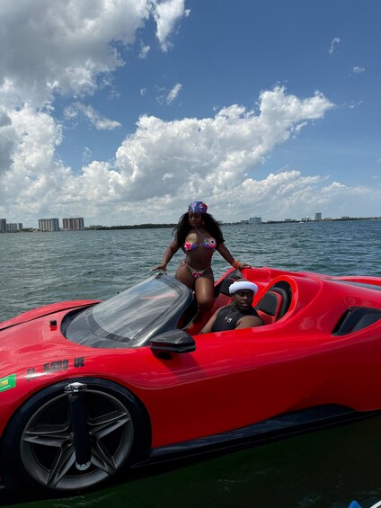 A person in a colorful swimsuit on a red jet ski with a city skyline in the background. 5