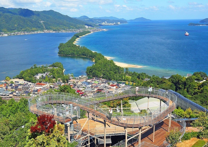 A coastal city with a large stadium, a beach, and a ship in the distance. 1