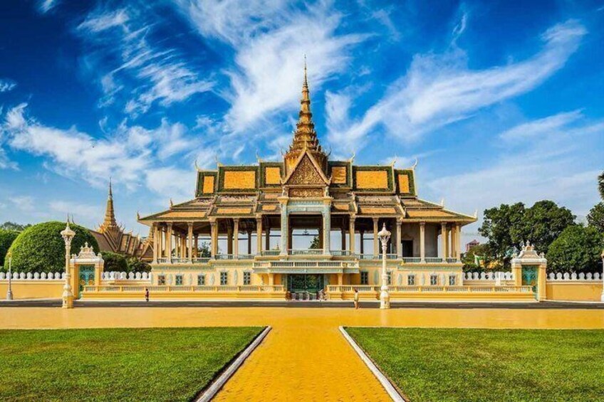 A traditional Thai building with a central spire, surrounded by a well-maintained lawn and a yellow pathway. 1
