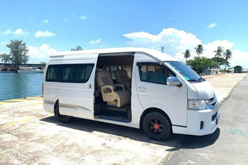 A white van parked by a waterfront with an open door, revealing the interior. 3