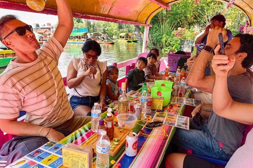 A group of people on a boat with a table full of items. 3