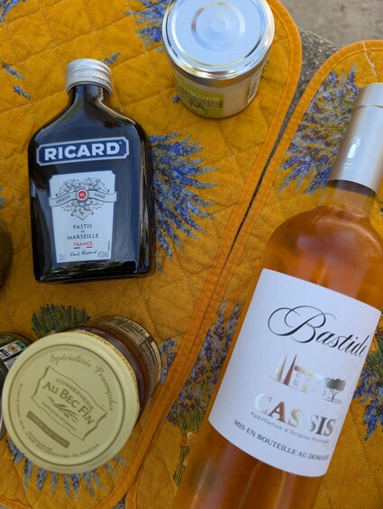 A table with bottles of wine and a jar of preserves. 3
