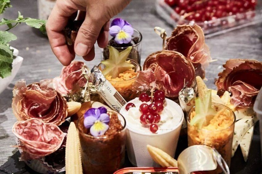 A variety of food items including meats, cheeses, and garnishes on a wooden table. 5