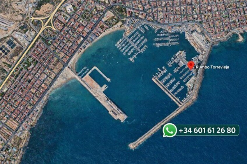 An aerial view of a coastal city with a marina, a prominent bridge, and a marked location named 'Rumbo Torrevieja.' 2