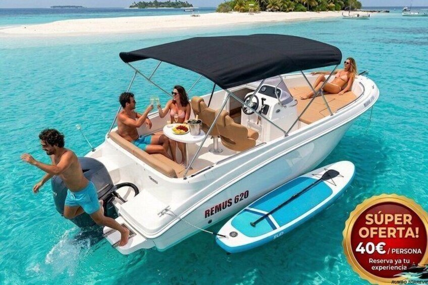 A boat with people on it, a beach, and a sign offering a 40€ per person discount. 1