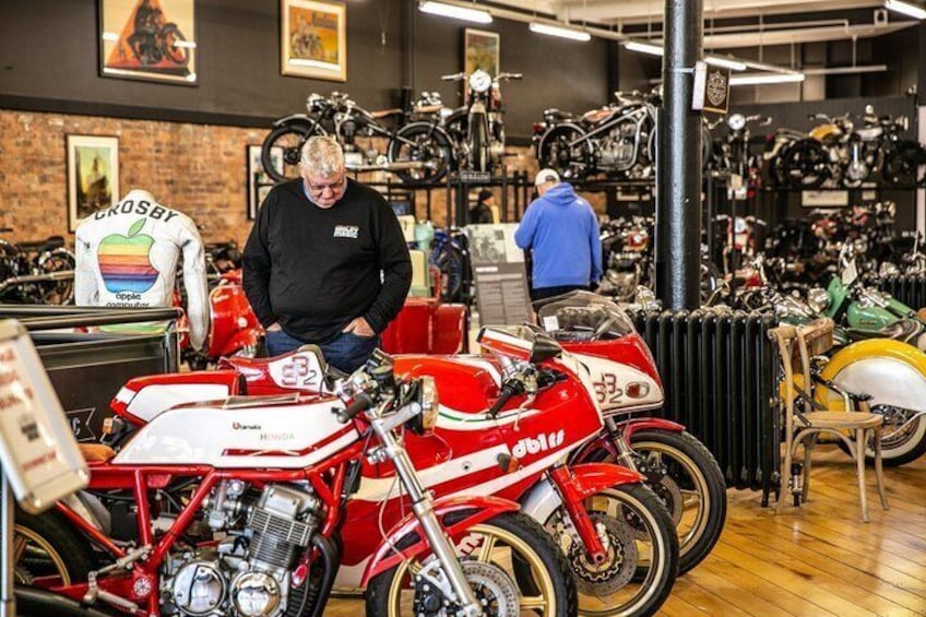 A motorcycle shop with red bikes and a man inspecting a bike. 3