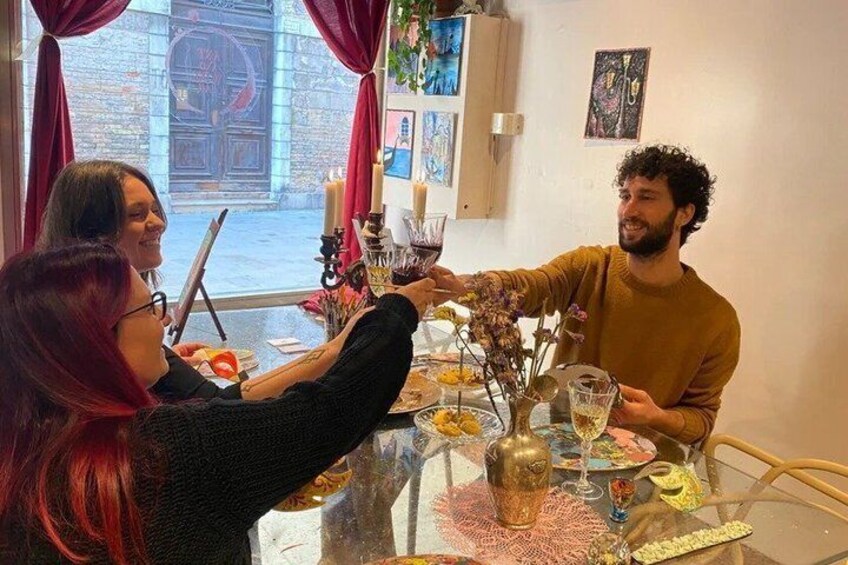 A dining table with a glass top, candles, and a vase with flowers. 3