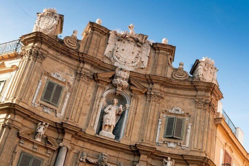 A historic building with ornate architectural details, including statues and decorative moldings. 4