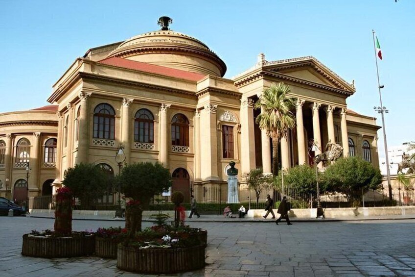A classical building with columns and a dome, surrounded by trees and a flag. 2