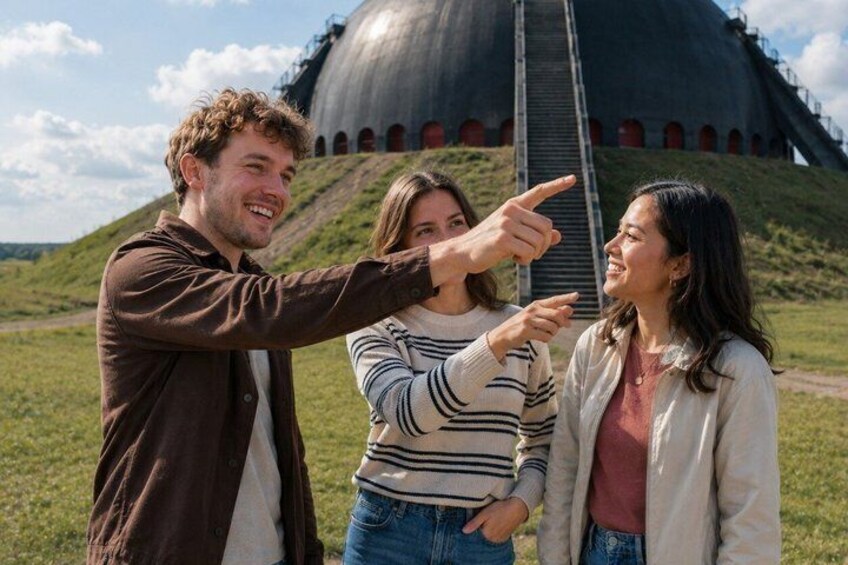 Three people pointing at a large, dome-shaped building with a staircase leading up to it. 5
