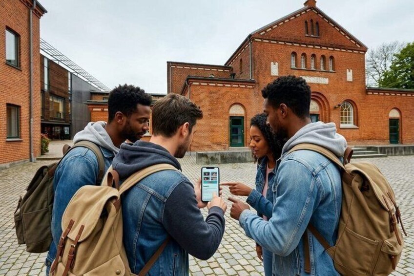 Four people standing outdoors, one holding a smartphone, with brick buildings in the background. 1