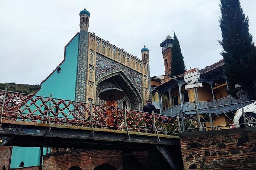 A bridge with a turquoise building and a mosque with a minaret. 2