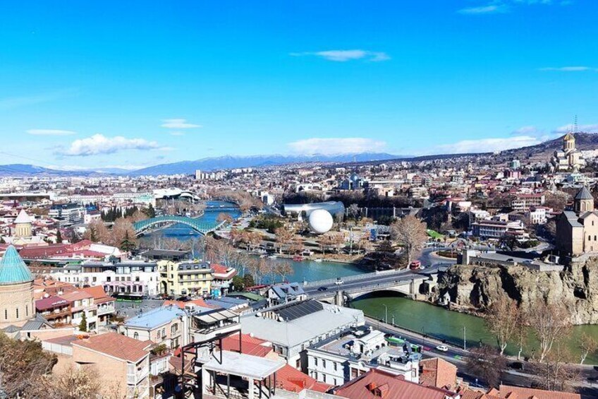 A cityscape with a prominent bridge, a river, and a historic building with a dome. 1