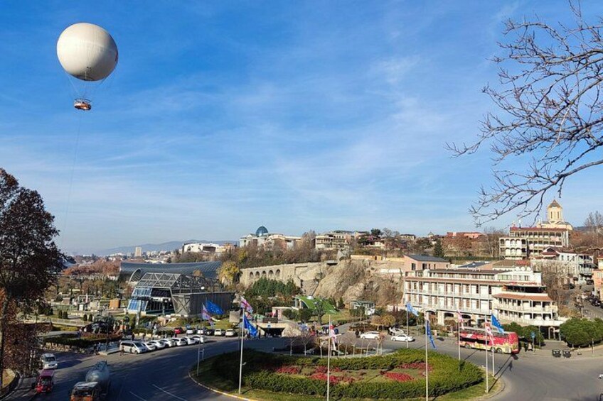 A cityscape with a large spherical structure, a dome-shaped building, and a modern building with a glass facade. 4