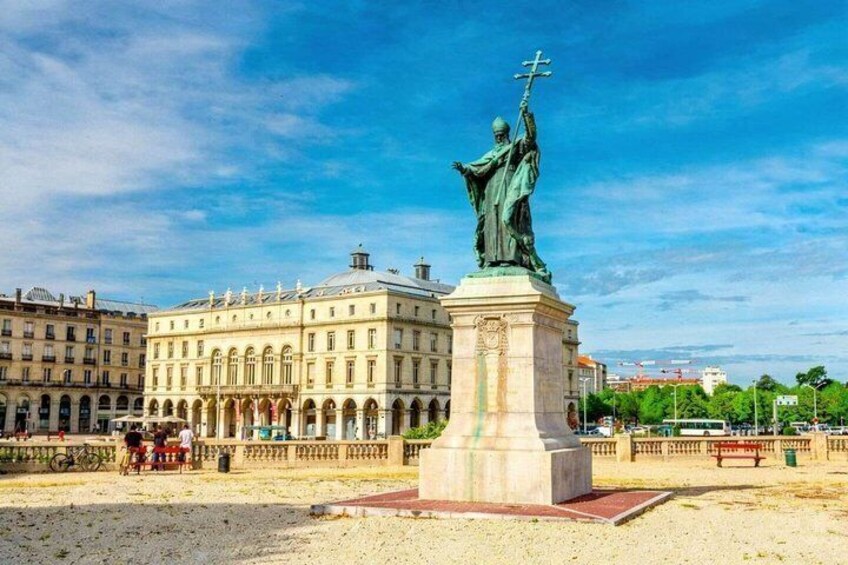 A statue on a pedestal in a square with a building in the background. 5