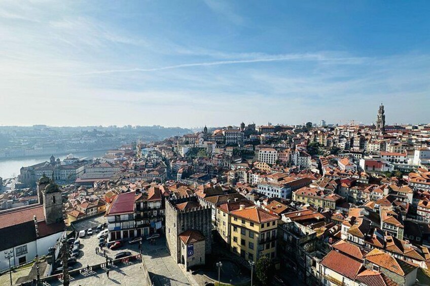 A panoramic view of a historic city with dense architecture, a prominent tower, and a river in the background. 2