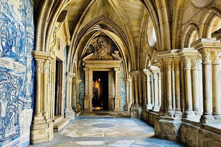 A Gothic architectural corridor with stone columns and blue patterned walls. 1