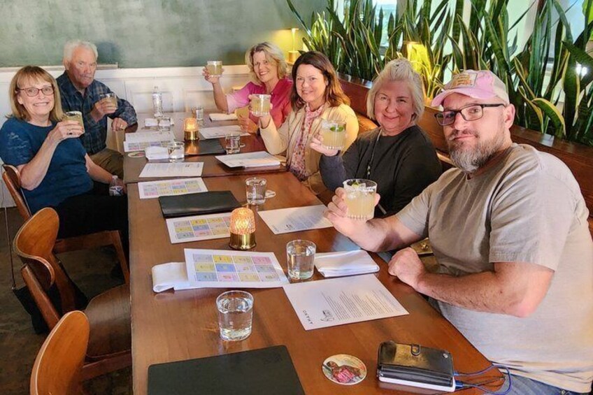 A group of people seated at a long wooden table with papers, glasses, and a candle. 5