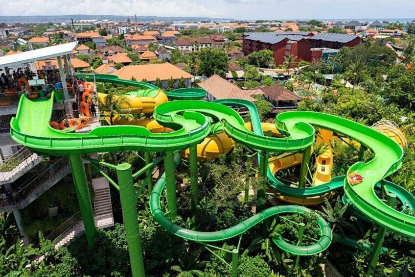A water park with multiple water slides and a view of a residential area in the background. 1