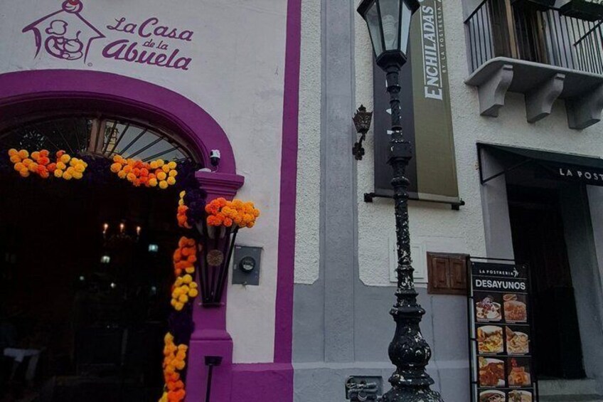A building with a purple archway and a sign that reads 'La Casa de la Abuela.' 5