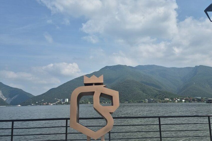 A boat with a large, abstract sculpture in the foreground and mountains in the background. 4