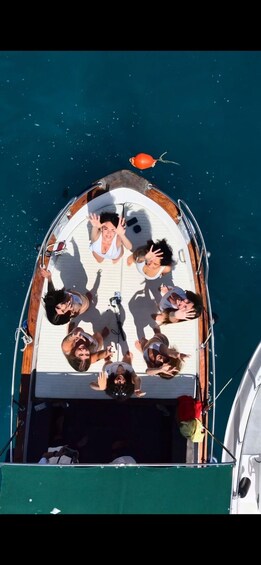 A group of people on a boat with a fish above them. 5