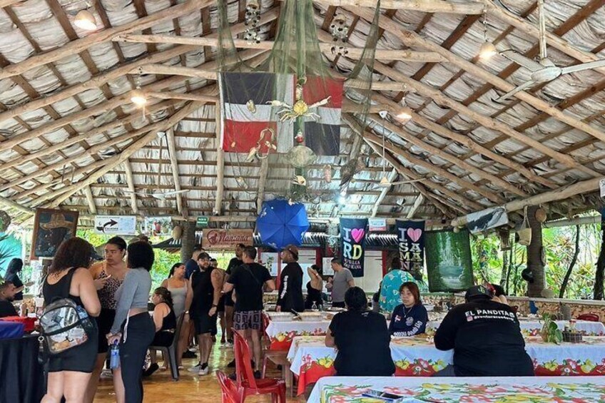 A covered outdoor event with tables and people. 5