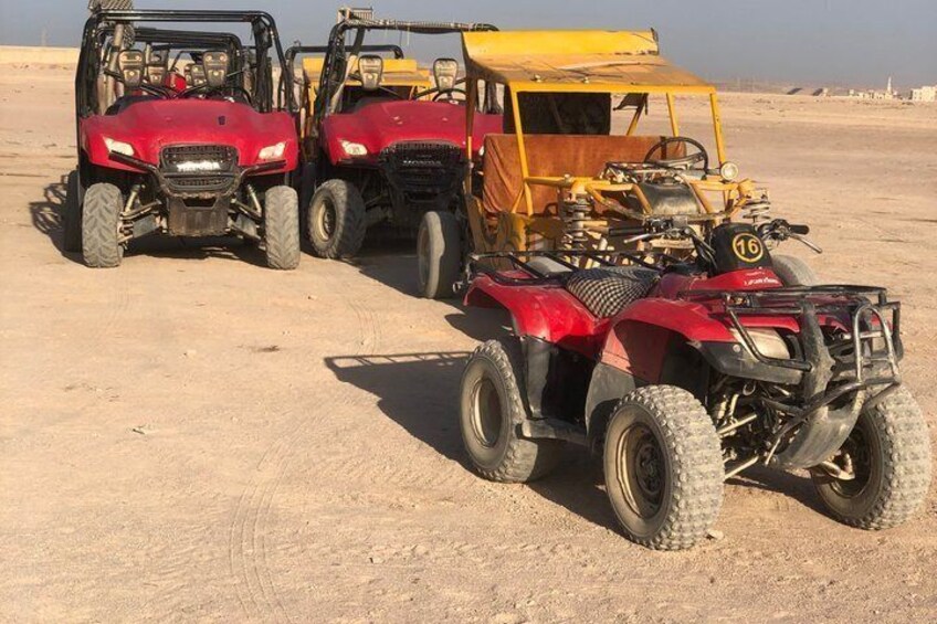 Three off-road vehicles parked on a sandy terrain. 3