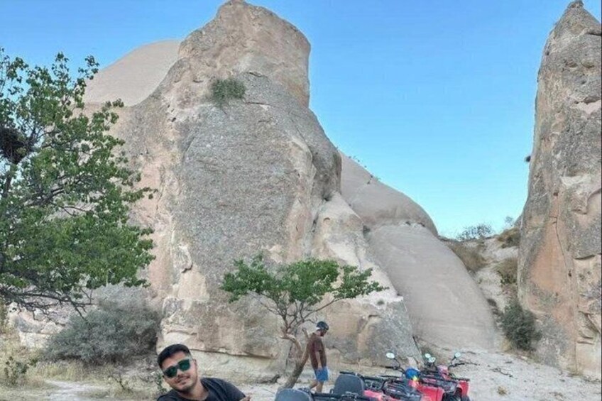A rocky landscape with a prominent rock formation and a small tree. 3