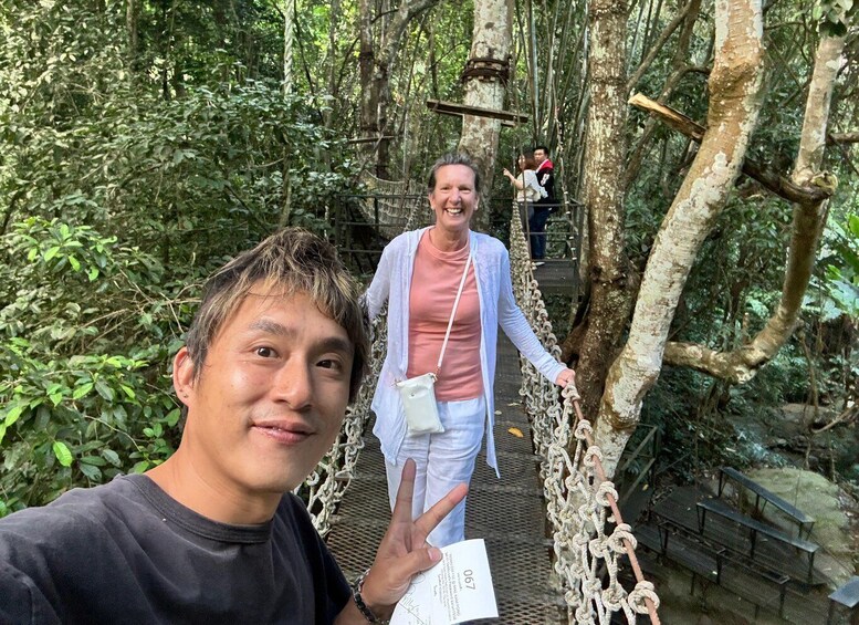 A person on a rope bridge in a forested area. 1