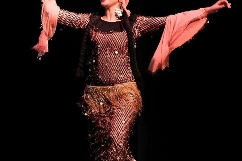 A person in a patterned outfit with arms outstretched. 4