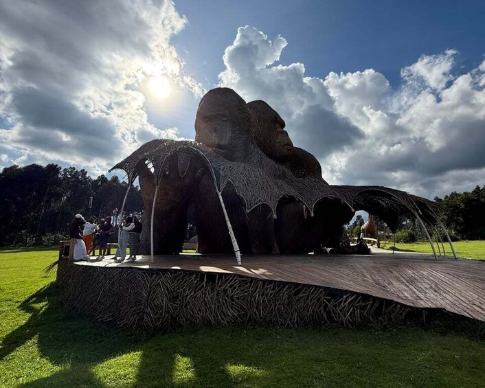 A large rock formation with a wooden platform and visitors. 4