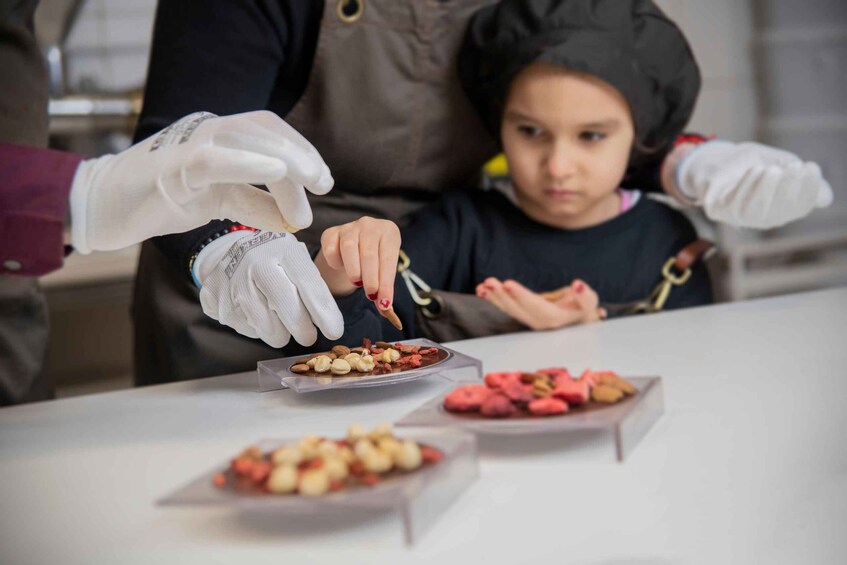 A person wearing gloves handing food to a seated individual. 5