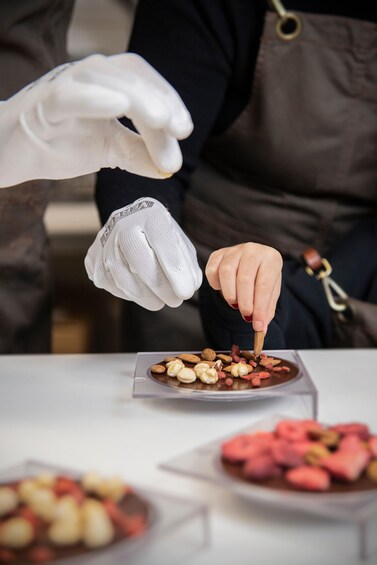 A person wearing gloves handling food items on a table. 1