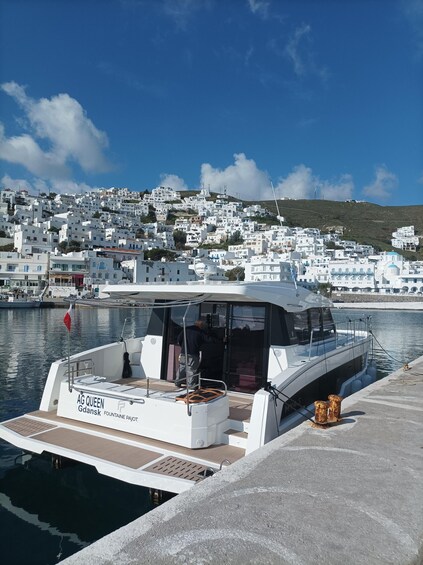 A white yacht named AG QUEEN Gdansk docked at a marina with a backdrop of white buildings on a hillside. 2