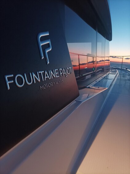 A yacht with the logo 'FOUNTAIN PAJOT MOTOR YACHTS' and a sunset in the background. 4