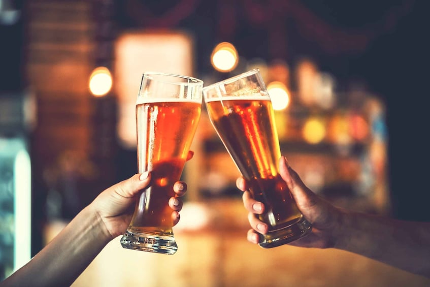 Two hands holding glasses of beer, toasting. 1