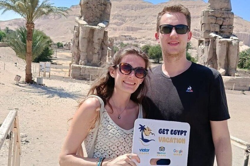 Two people holding a 'Get Egypt Vacation' brochure. 1