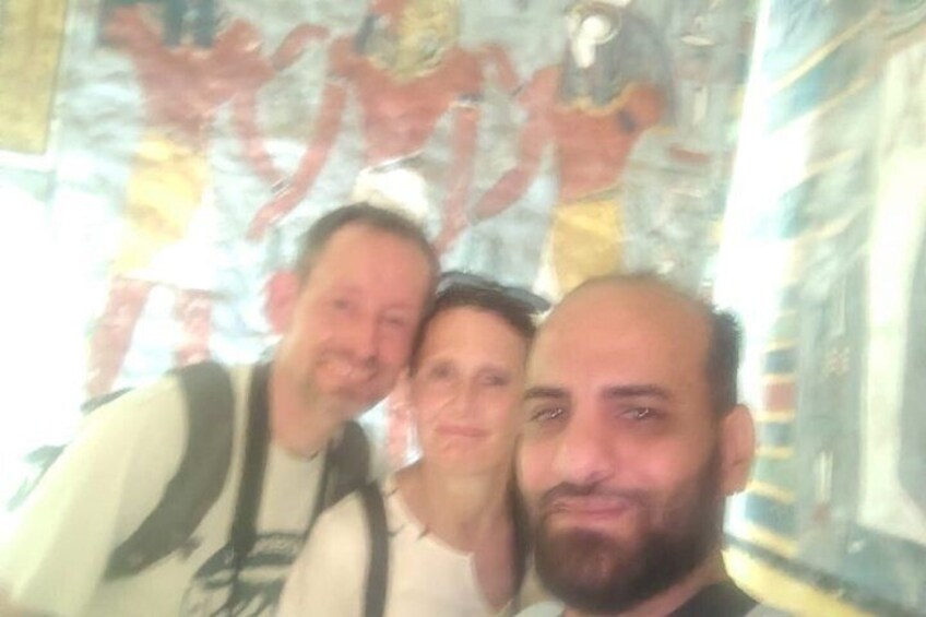 Three people in a room with a mural on the wall. 4