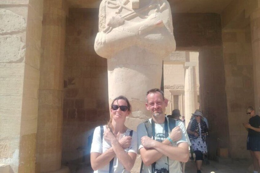 A man and a woman standing in front of a large stone structure with hieroglyphics. 4