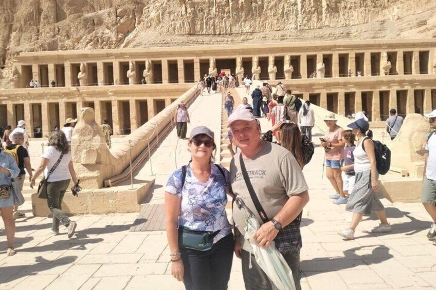 Tourists at a historical site with ancient stone structures and a large staircase. 1