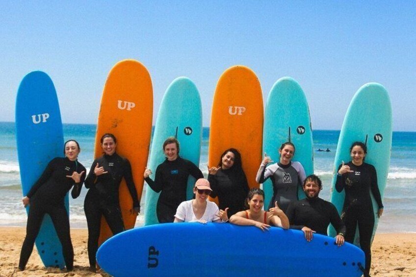 A group of people on a beach with surfboards. 2