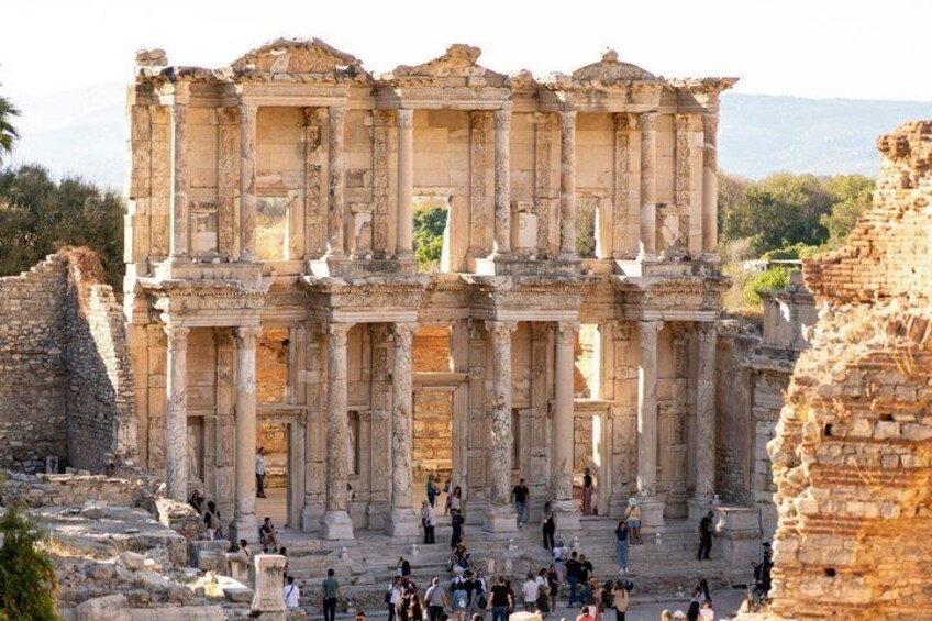 An ancient ruin with columns and steps, surrounded by visitors. 5