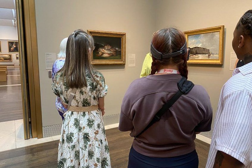 People viewing paintings in a gallery. 1